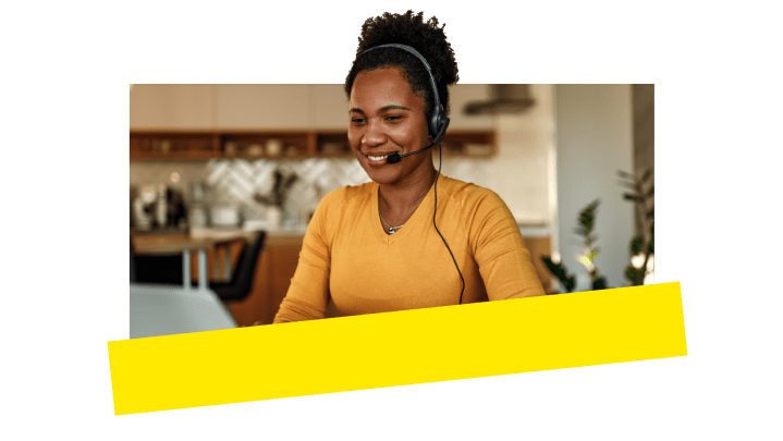A support agent smiling while offering a customer help.