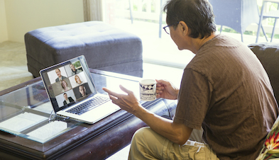 Man videoconferencing from his couch at home with coffee mug