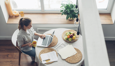 Woman working from home with cup of tea and laptop