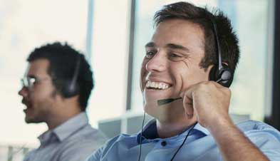 Customer service representative laughing while  using GoToConnect with headset