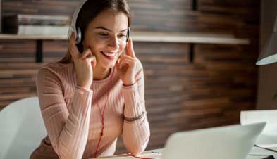Woman listening to recorded webinar on headphones