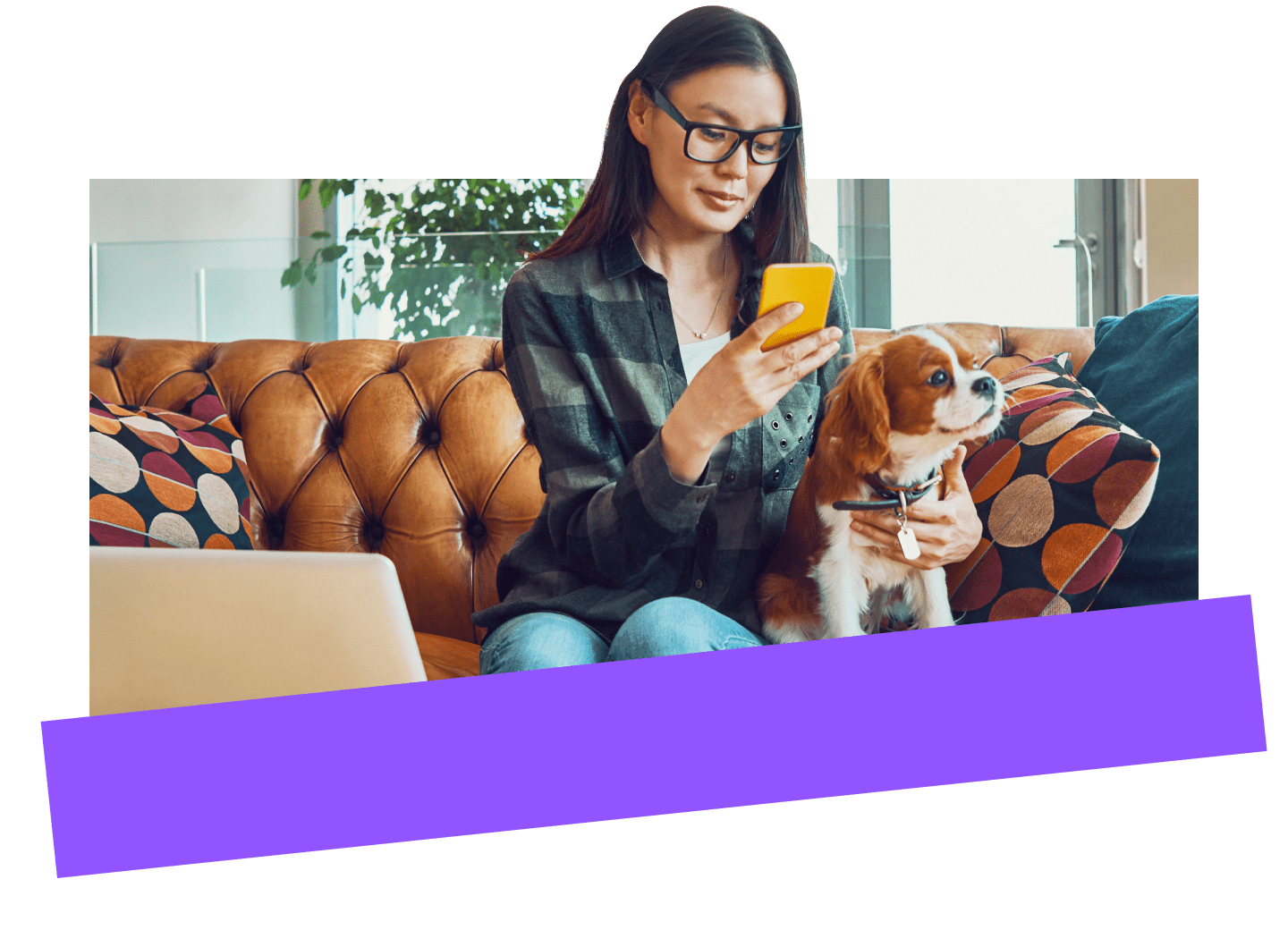 Une employée à distance utilise un appareil mobile en toute sécurité pour gérer son activité tout en travaillant à domicile avec son chien.